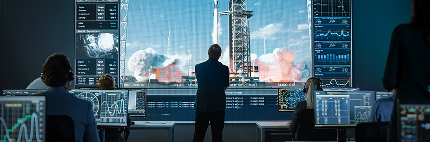 Man in front of rocket launch screen